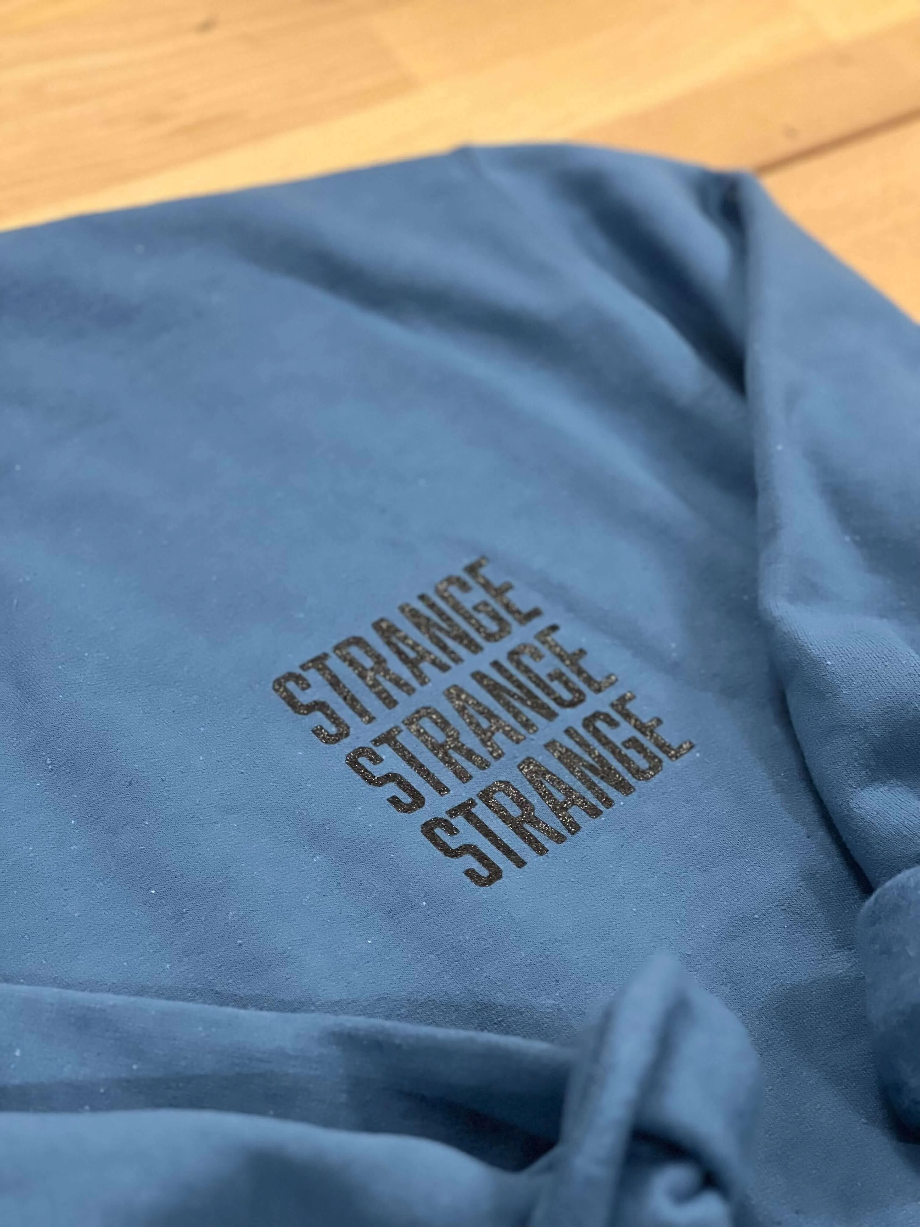 "Strange Strange Strange" small logo crewnecks