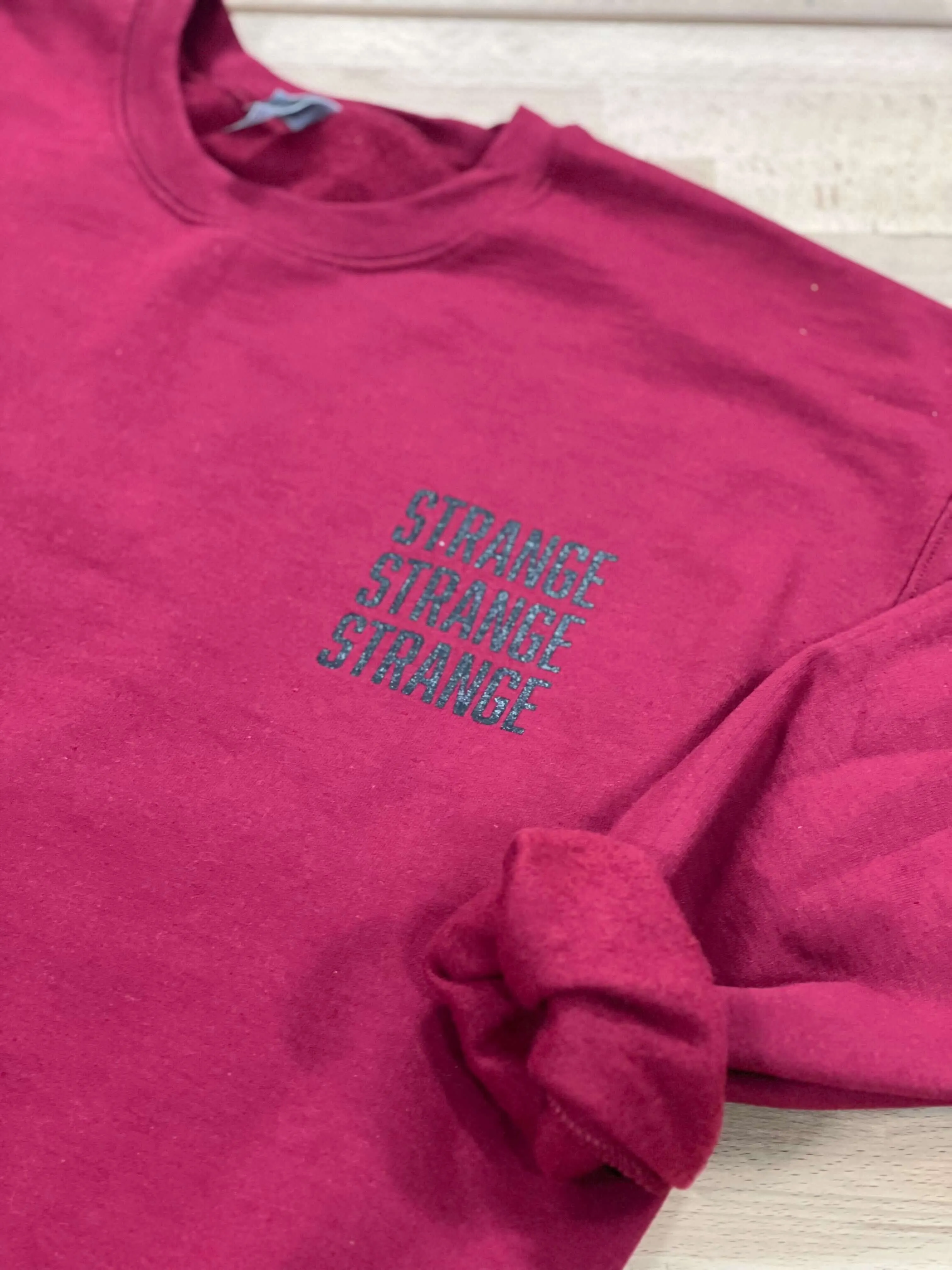 "Strange Strange Strange" small logo crewnecks