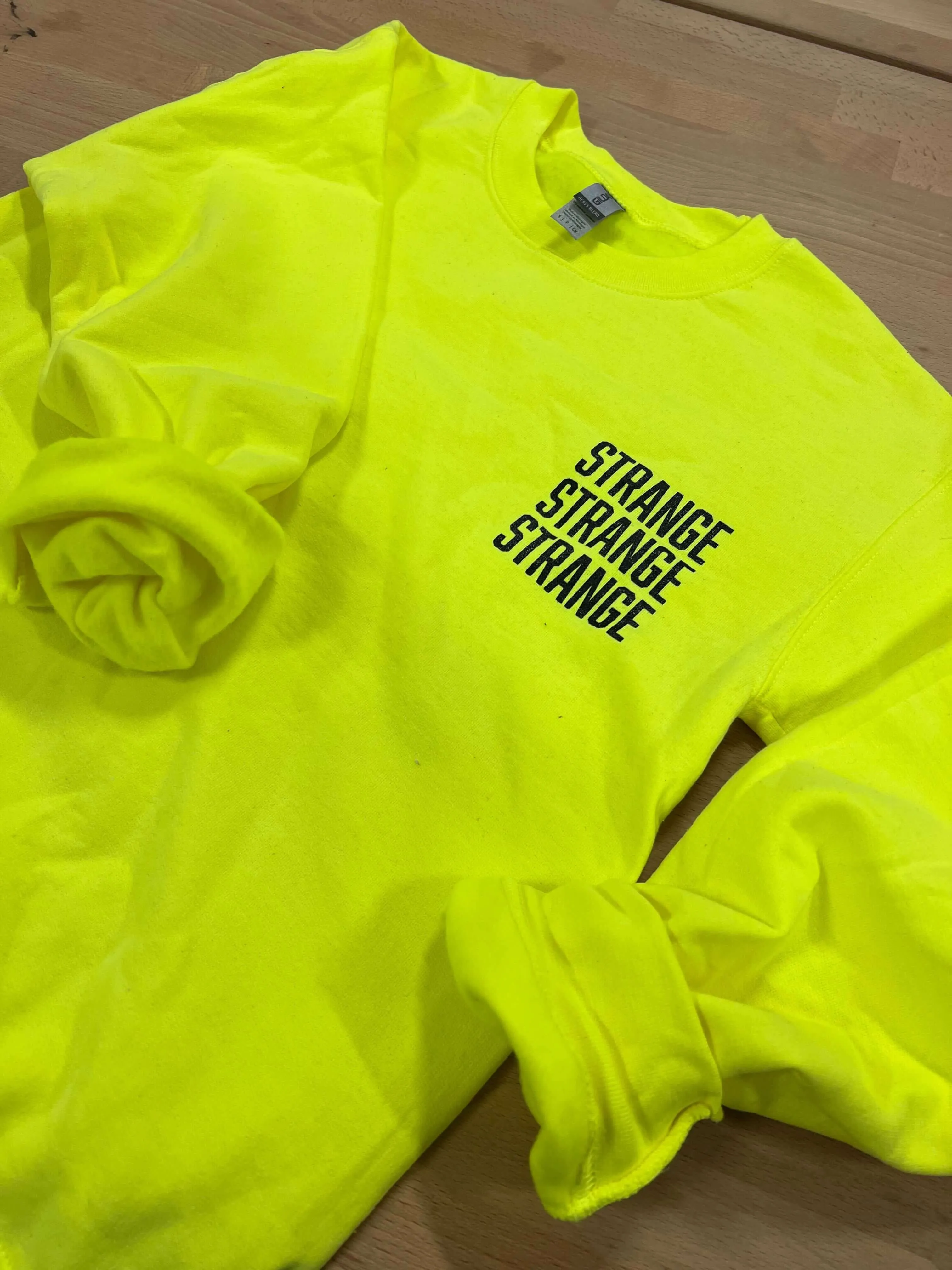 "Strange Strange Strange" small logo crewnecks