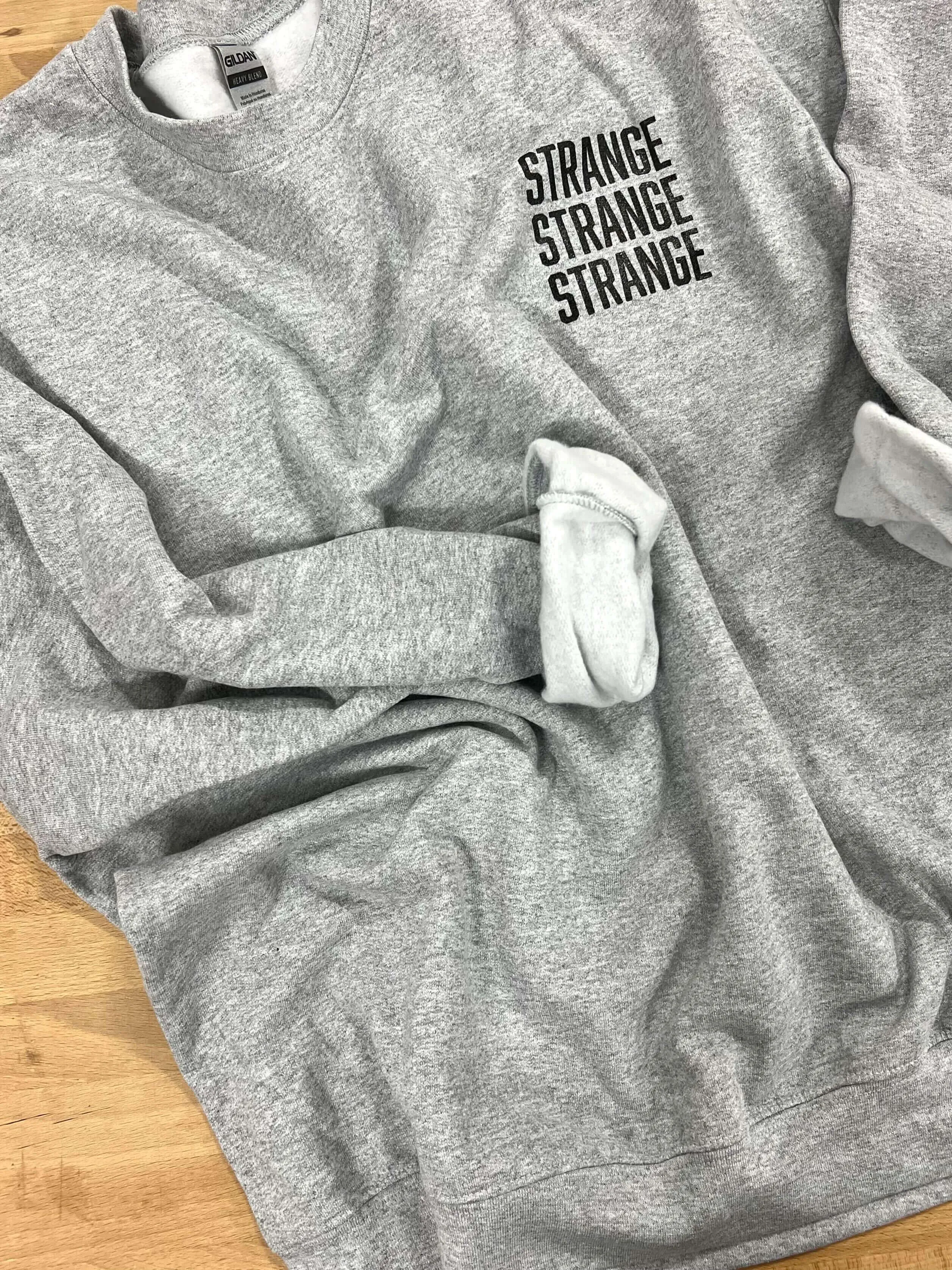 "Strange Strange Strange" small logo crewnecks